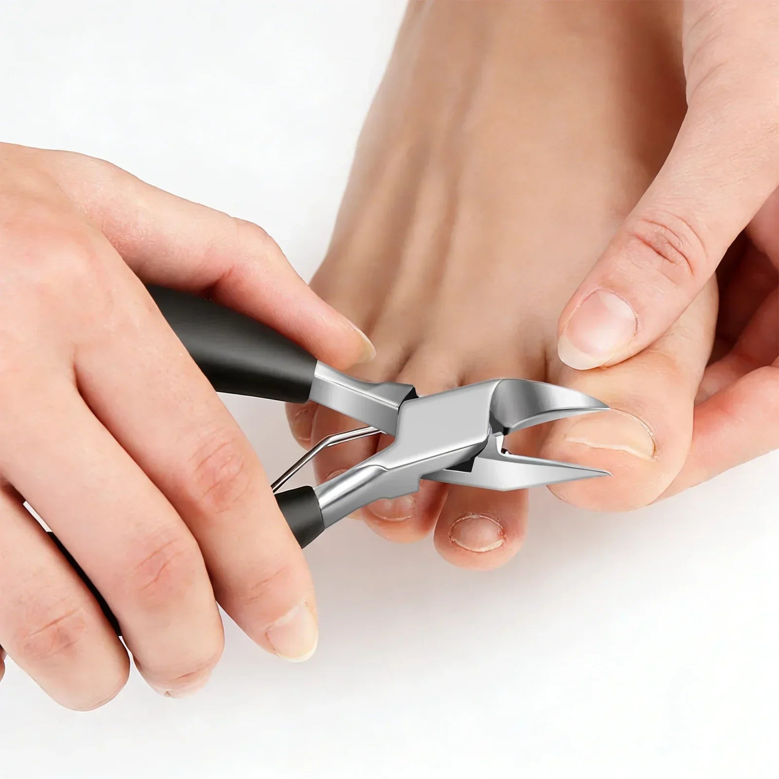 Stainless steel toenail clippers trimming thick toenails, close-up on hands and tool.